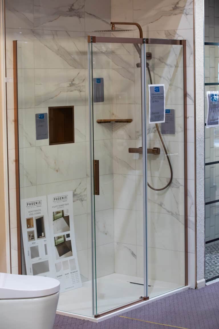 A walk in shower enclosure with a chrome shower and marble effect tiles