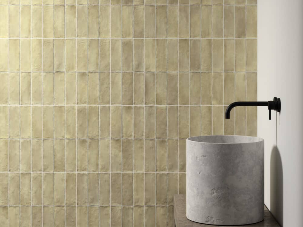 Craven Dunnill Sabbia Weald Green square wall tiles behind a concrete cylindrical basin with a matt black wall tap