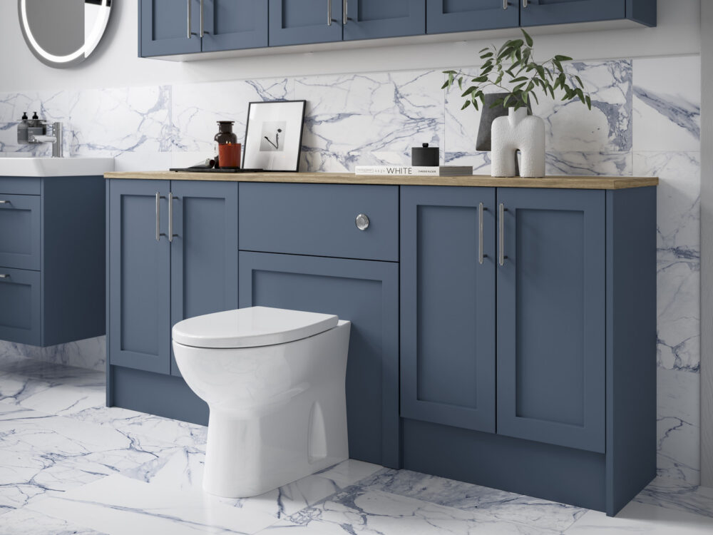 Veldeau Winson muted blue shaker fitted furniture with an oak worktop and back-to-wall WC against marble