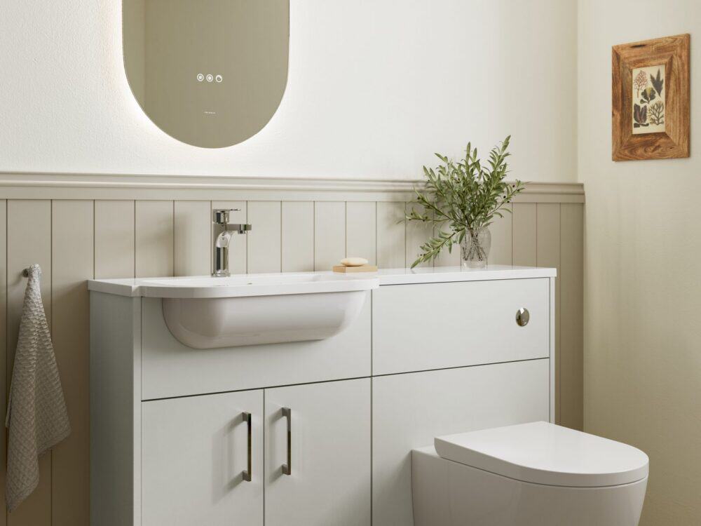 Veldeau Bourton antique white fitted furniture with a curved basin and panelled wall