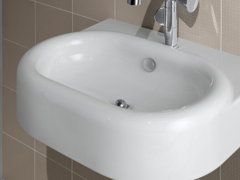 VitrA white wall-hung washbasin with a chrome mono mixer against beige tiling