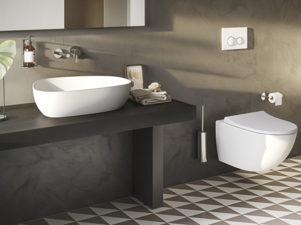 VitrA Outline countertop washbasin on a dark counter with a wall-hung WC and concrete walls