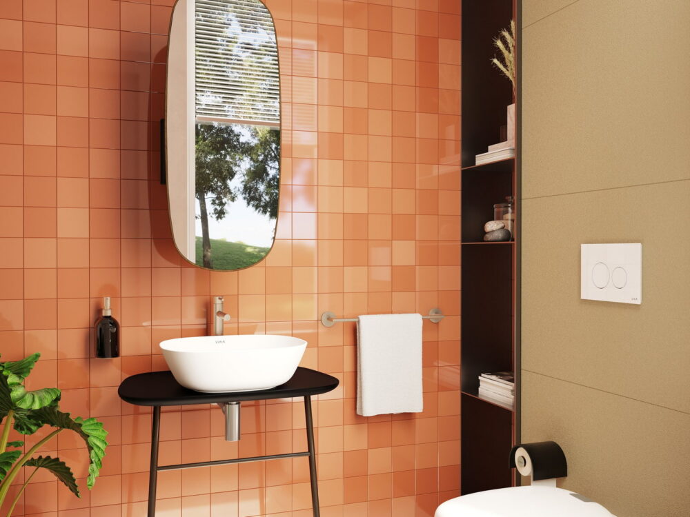 VitrA Plural black countertop washbasin on a slim stand against terracotta tiling