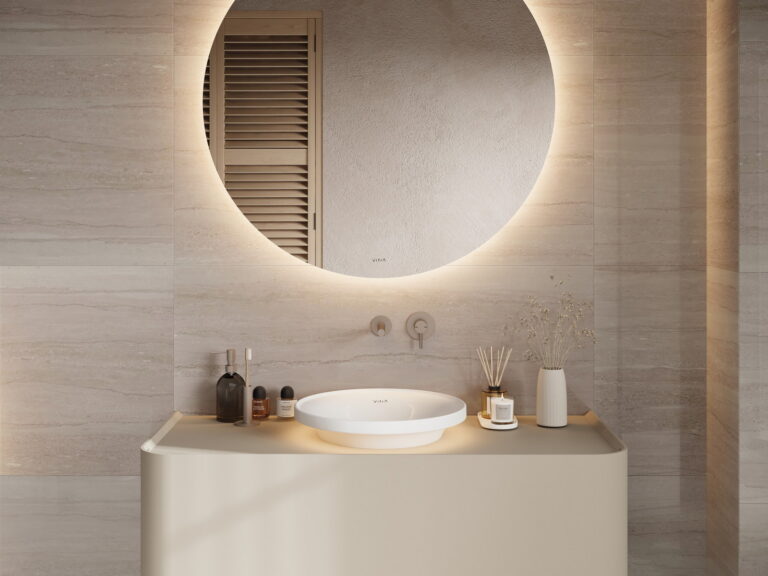 VitrA round illuminated mirror with a backlit glow above a curved cream vanity unit