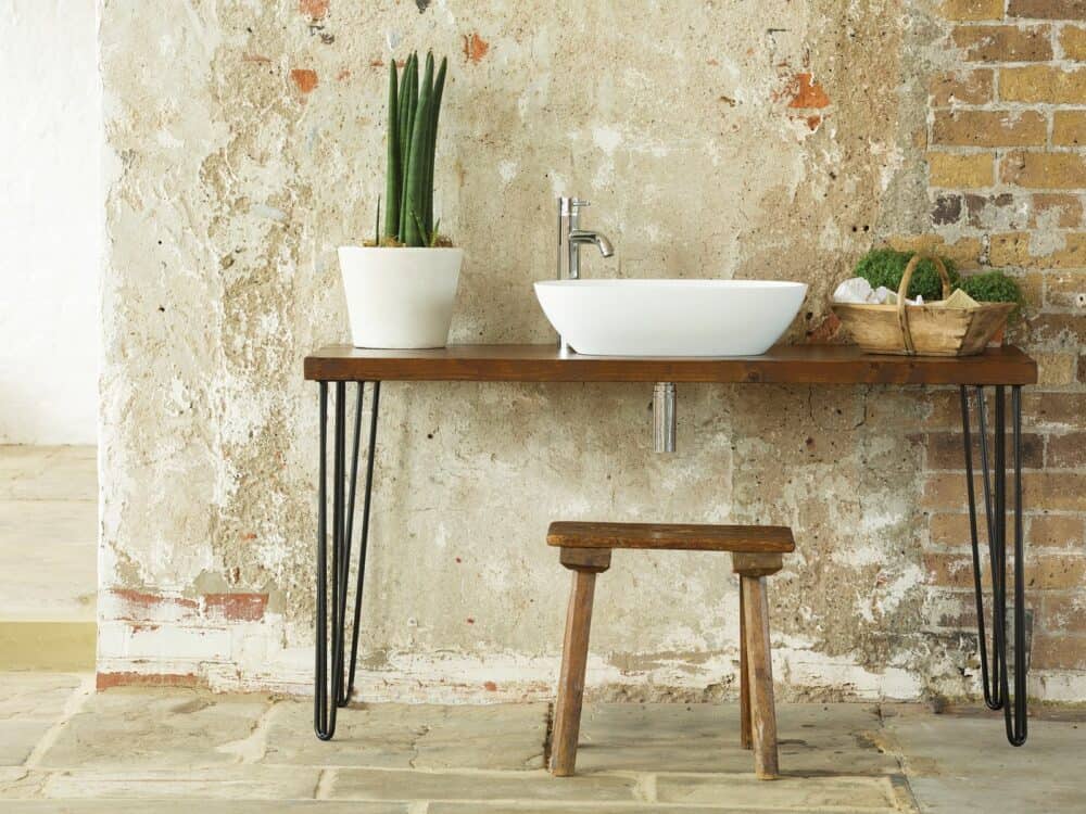 Waters Dawn countertop basin on a timber washstand with hairpin legs against exposed brick