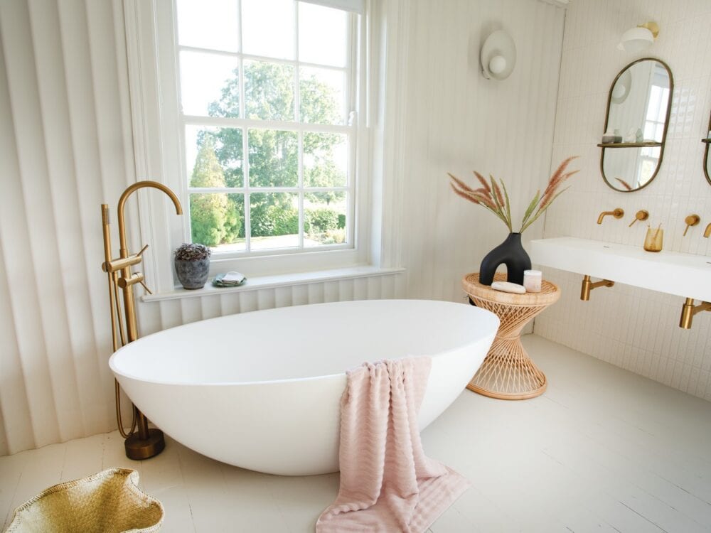 Waters Escape freestanding bath with gold taps, an arched mirror and a fluted wall