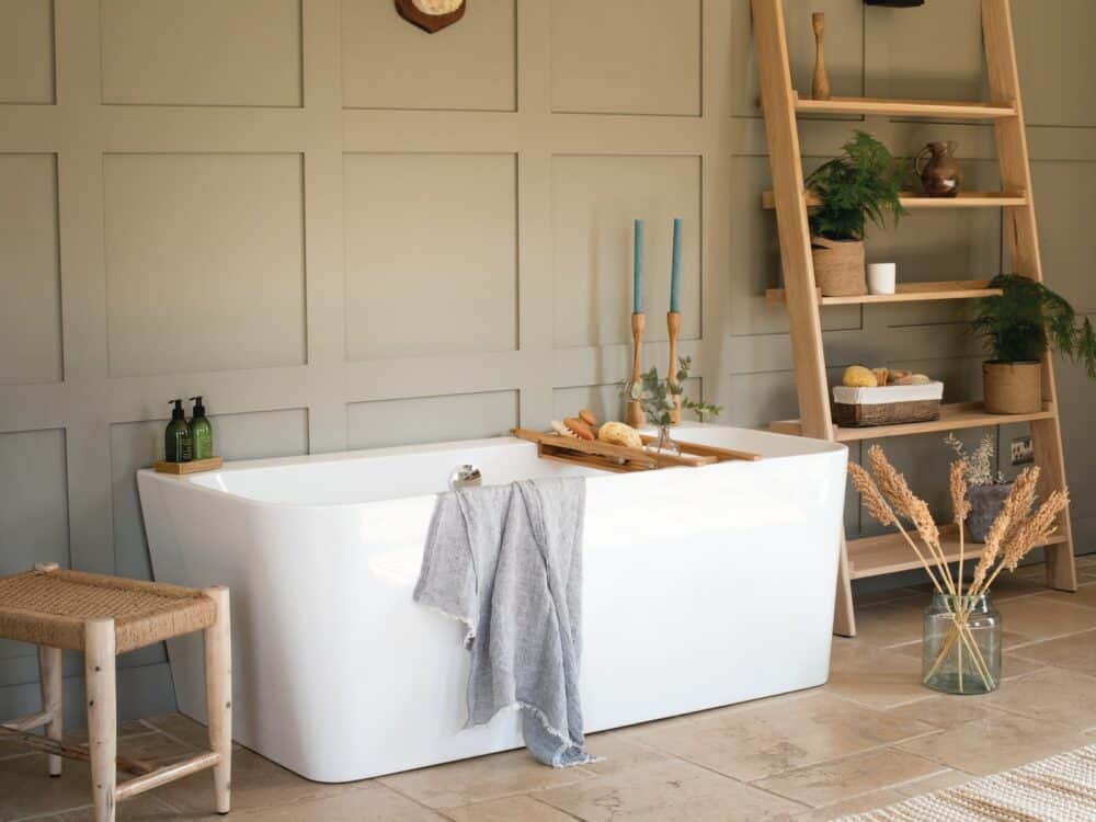Waters River bath against a green panelled wall with a ladder shelf and bath tray