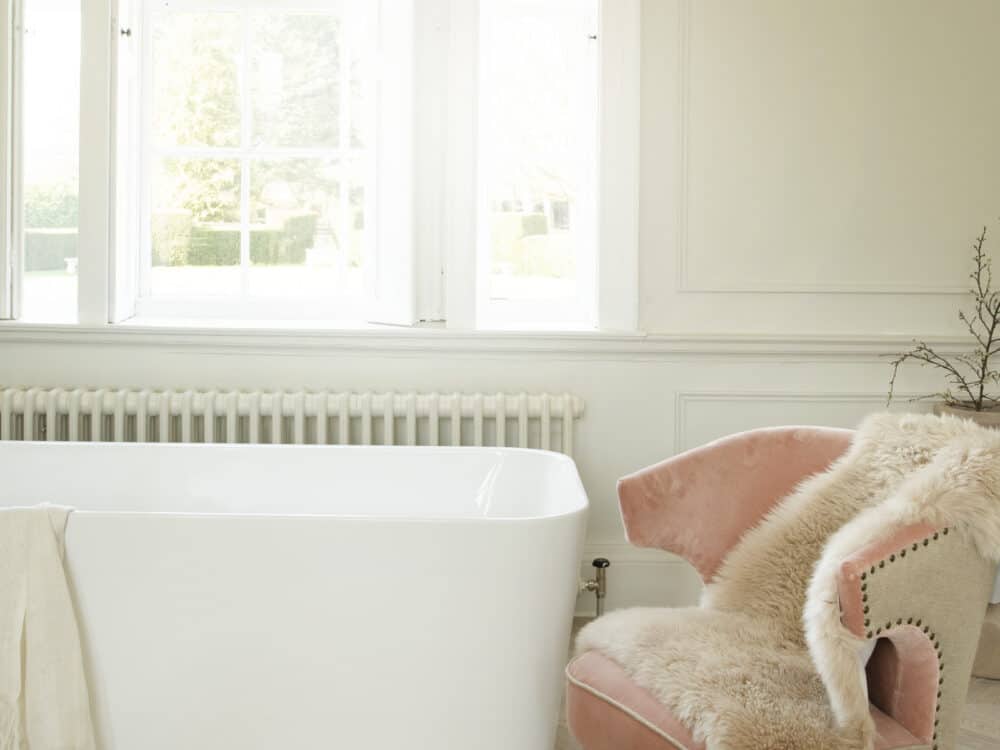 Waters Pool bath in a pale panelled room with sash windows and a pink armchair