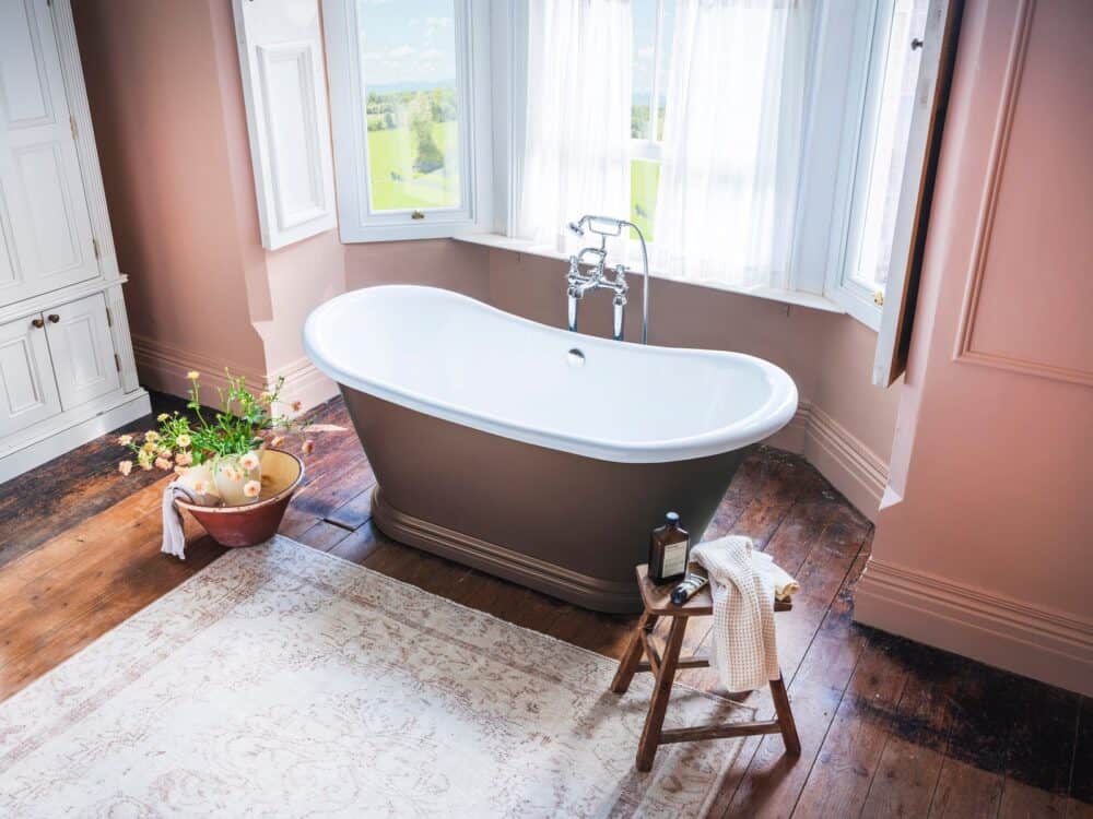 Waters Darcy roll-top bath in a bay window against a soft pink wall